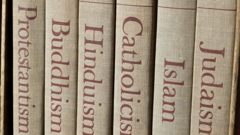 Imagine showing a row of tan books with different religions written on the spines: Judaism, Islam, Catholicism, Hinduism, Buddhism, Protestantism